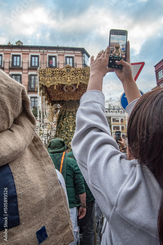 A woman uses her mobile phone to photograph a float with a Virgin Mary during a Holy Week procession in Madrid, Spain.