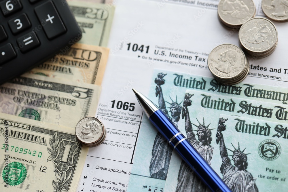 American US dollars money bills and coins with pen and calculator on IRS tax form blanks American US dollars money bills and coins with pen and calculator on IRS tax form blanks