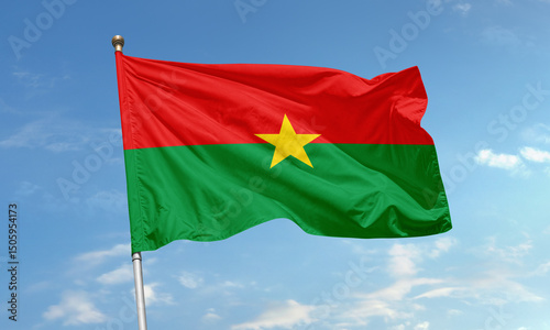 Принти на полотні Flag of Burkina Faso with red, green, and yellow star flying in the wind under a