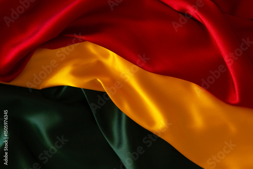 Black History Month, Juneteenth background. Red, yellow, green colors satin silk flag draperies. Top view