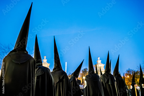 Nazarenes in black hoods during Holy Week procession in Seville