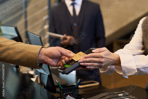 Wallpaper Mural Two people engaging in payment exchange using credit card at reception counter. Focus on hands and card, with blurred background of suited individual Torontodigital.ca