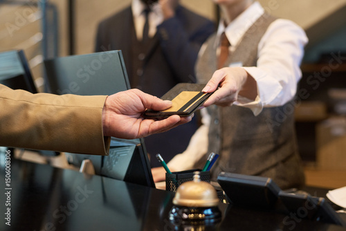 Wallpaper Mural Receptionist taking credit card from guest at hotel reception for transaction processing. Elegant setup with polished service tools like bell and pen holder visible on counter Torontodigital.ca