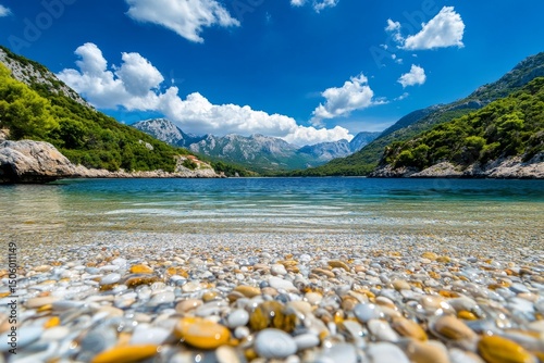 Crystal Clear Water Reveals Colorful Stones Beneath Sunny Skies in Scenic Coa...