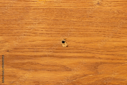Hole in wooden surface, background for furniture repair themes, hole in the center