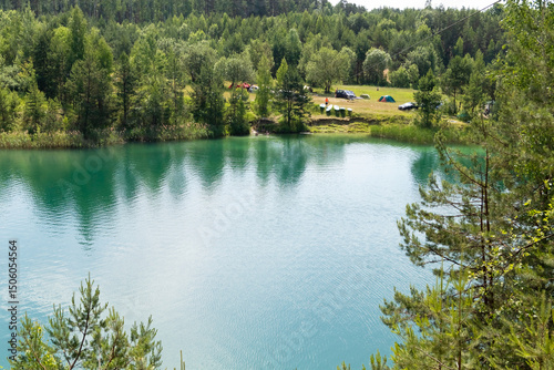 Beautiful summer landscape - a lake surrounded by green trees against a blue sky