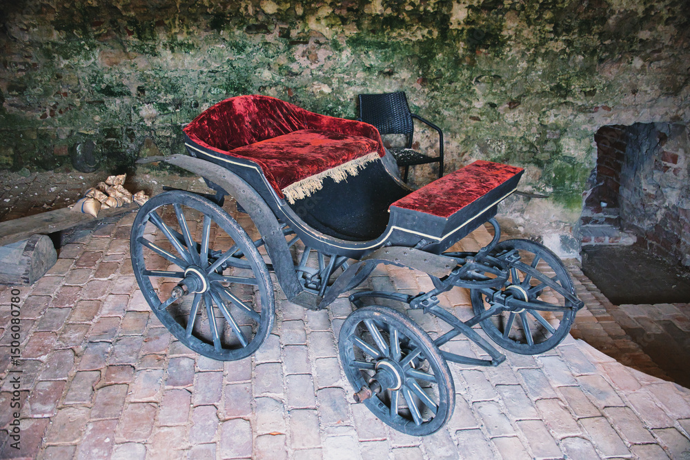 Fototapeta premium Antique Horse-Drawn Carriage with Red Velvet Upholstery in Rustic Setting
