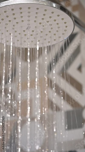 Slow-motion shot of water falling from a showerhead, capturing the flow and motion of individual water streams