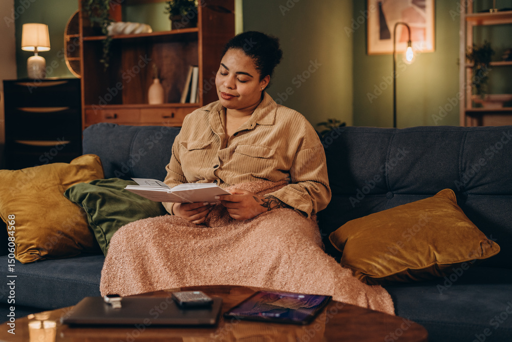 Obraz premium African American woman reads book missing call on tablet placed on table