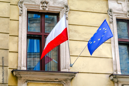 National Polish,blue with stars European Union flags hanging on government embassy building house.independence or labor day,friendship of countries.Town Krakow, Poland.