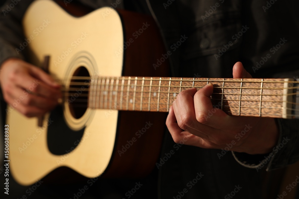 Fototapeta premium Man playing guitar on black background, closeup