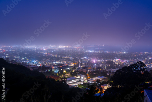 Fotografie Night view of a city with a bridge in the distance under a purple sky