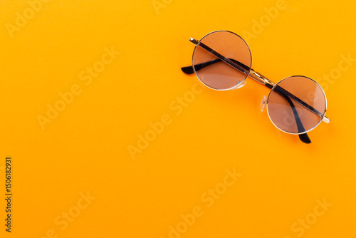 Blue sunglasses on color background, top view