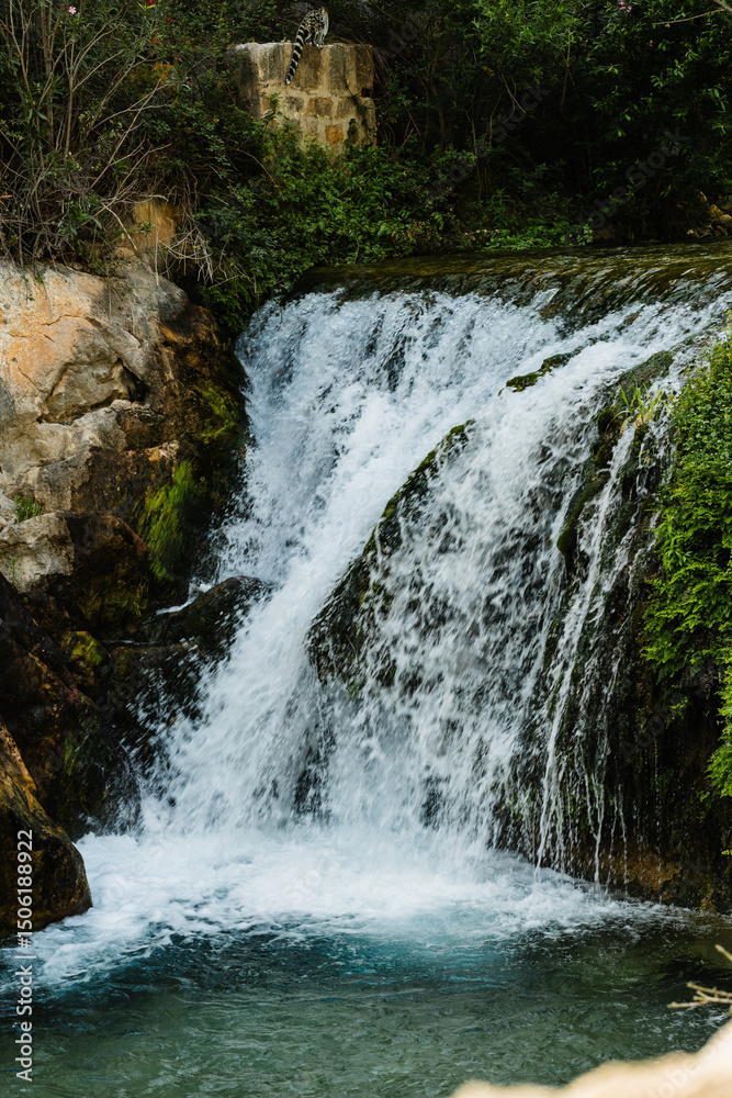 Obraz premium Clear waterfall water flows over rocky ledge. Image suitable for nature, travel, or relaxation context and purpose.