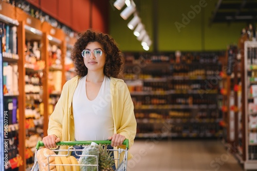 Young woman pushing shopping cart in grocery store