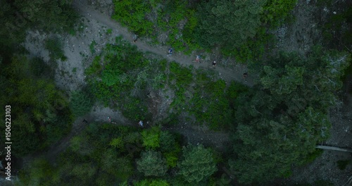 Wallpaper Mural Group of runners on narrow, swerving dirt path in canyon - epic drone shot Torontodigital.ca