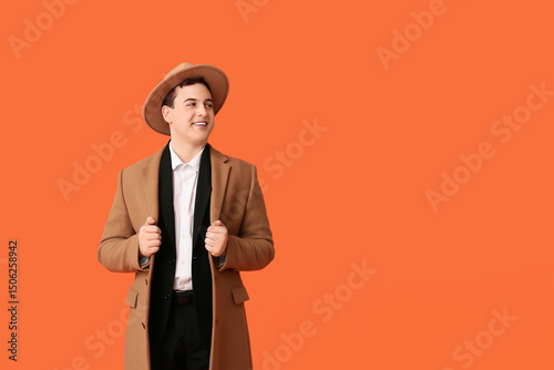 Young man in coat taking of...