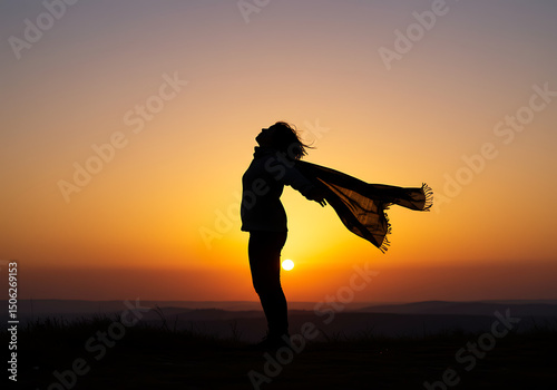 Silhouette of a Woman Standing with Open Arms at Sunset