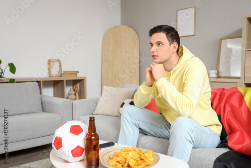 Young man watching soccer g...