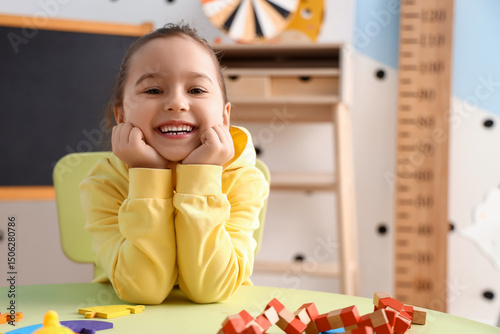 Cute little girl sitting at...