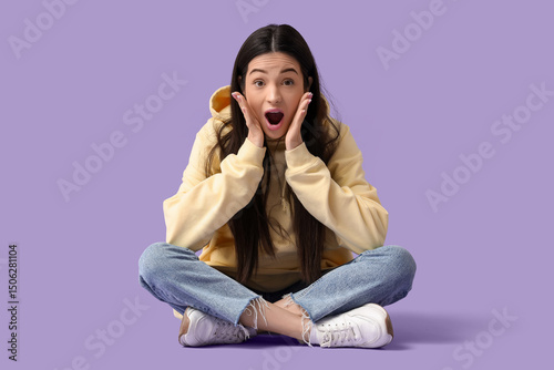 Surprised young woman sitti...
