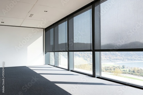 Empty office space with large windows overlooking a landscape