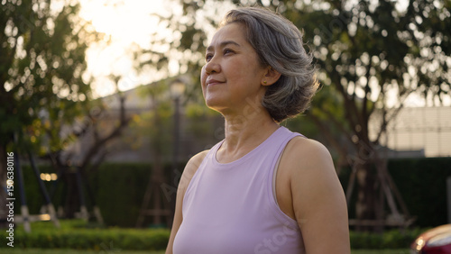 Asia adult aged people middle age mindful happy old woman open arm yoga deep calm stress relief outdoor nature public park sun light self love relax elder aging life asian female mental health care.
