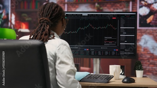 Day trader using PC to purchase and sell stocks, reading files, aiming to capitalize on market trends and fluctuations. Investor tracking stock forex trends on computer monitor, camera B