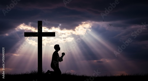 Silhouette of a kneeling figure by a cross against a cloudy sky with beams of light