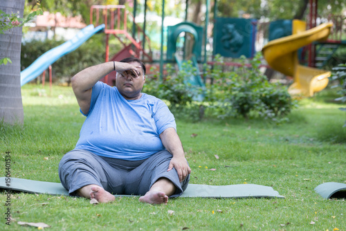 Indian man do yoga breathing exercise at summer park for stress management. Plus size or fat guy loose weight. Mental health and fitness lifestyle. Obesity problem.
