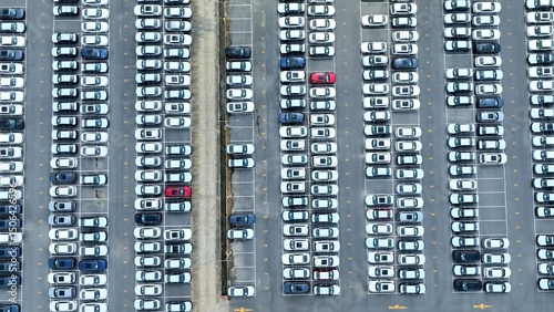 From above, the parking lot showcases rows of new cars waiting for distribution, emphasizing the critical role of organized storage in the logistics and supply chain of the automotive sector.