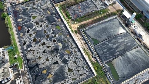 The site displays mixed containment conditions, active sludge ponds with compromised linings and a newer section ready for use or recently drained.
