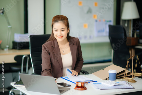Asian Female judge in a courtroom on white table and Counselor or Male lawyer working in office.
