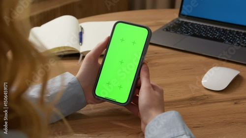 Woman use digital tech cell phone open green screen mock up. Hand press click phone web site down middle center. Girl hold mobile. Turn on chroma key page. Cozy home background. Online app copy space