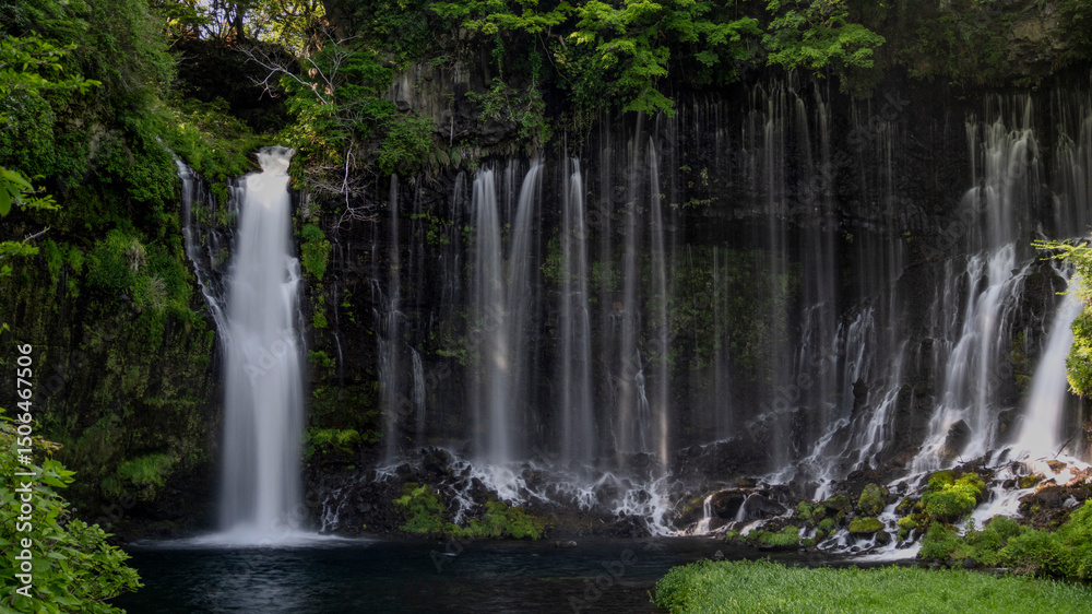 Obraz premium Breathtaking view of Shiraito no Taki waterfalls cascading down a lush, moss-covered cliff into a tranquil pool below.