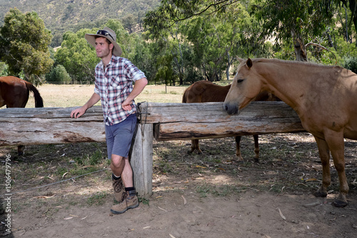 Young Adult Farmer Leaning on Fence photo