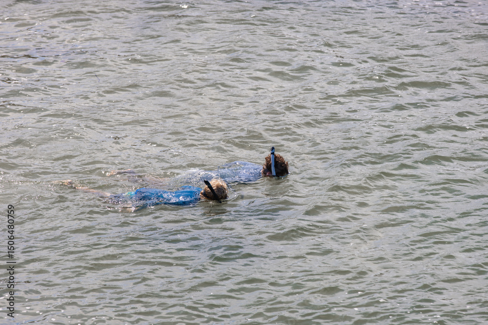 Fototapeta premium Two teenage boys snorkeling in the ocean on the Gold Coast during summer vacation in blue rashies