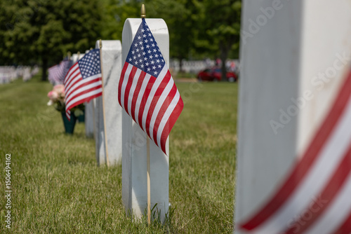 Close up sunny day view of military cemetery soldier gravestones decorated with an American flag