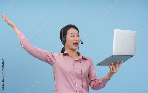 Young woman in headset happily presenting information during an online meeting against a blue background