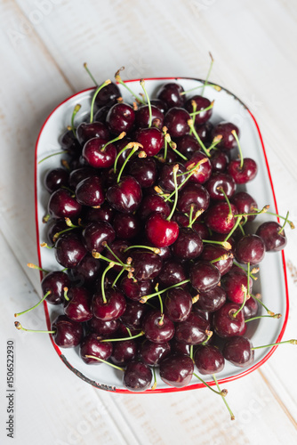 Fresh juicy cherries in an old enamelware dish photo