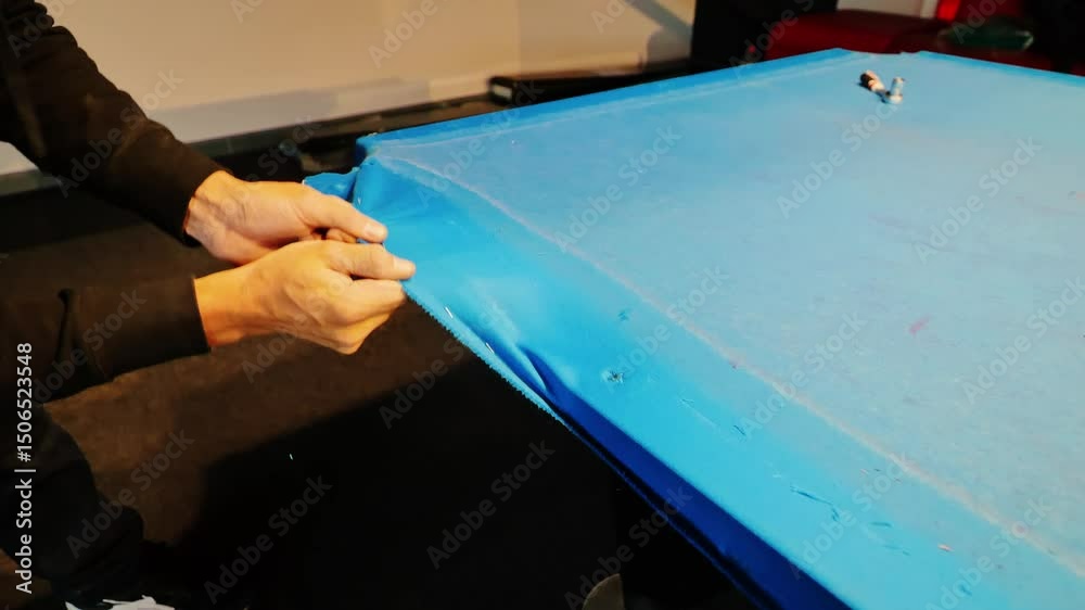 Restoration of worn billiard table as blue felt is carefully removed by hand, 4k