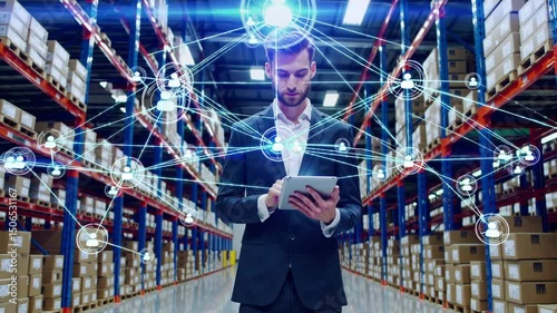 Warehouse Management & Digital Connectivity: A businessman expertly navigates the digital landscape within a warehouse, using a tablet to manage inventory and connect with a network of collaborators.