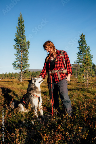Hiker woman petting alaskan malamute dog in vålådalen sweden a photo