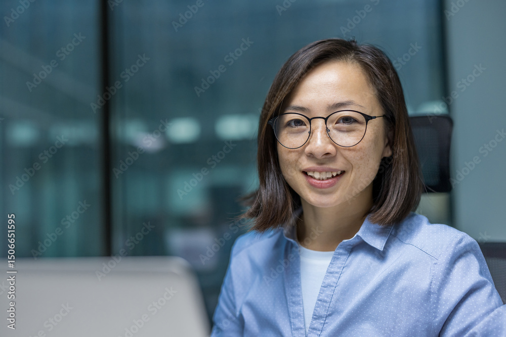 Ταπετσαρία A cheerful asian woman wearing glasses is smiling in a well-lit office environment