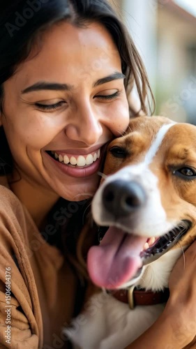 Happy smiling woman embraces her brown and white dog showing the long pink tongue, a moment of genuine joy and animal affection.