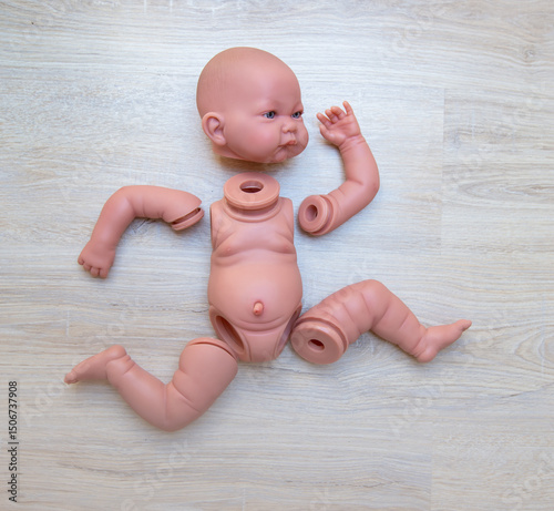 baby doll disassembled into parts lies on a shelf in the form of a runner