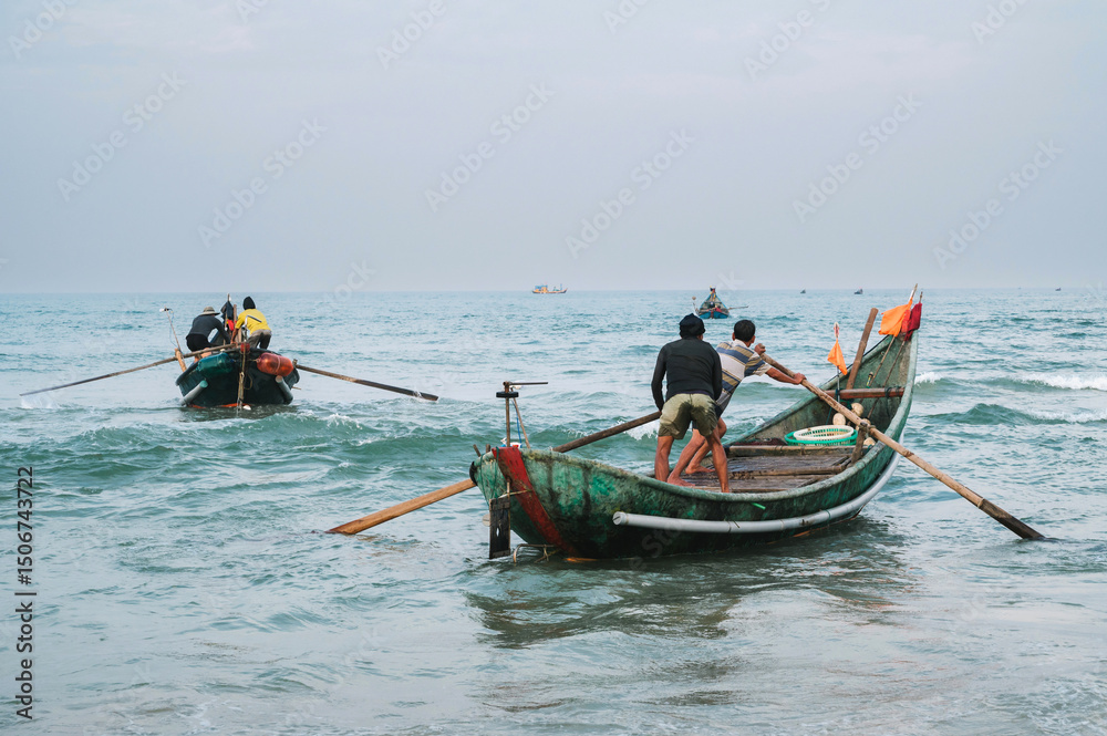 Naklejka premium Vietnamese fishermen men on traditional boats in sea at fishing village in Vietnam