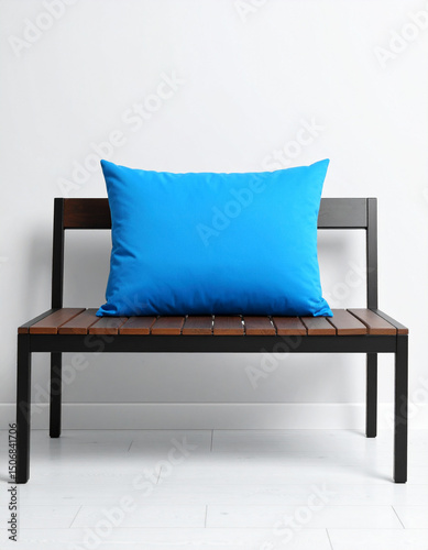 A single bright blue cushion rests on a minimalist bench, adding a comfortable pop of color to the clean lines.