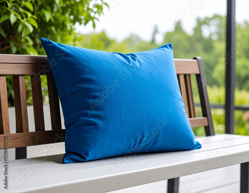 A single bright blue cushion rests on a minimalist bench, adding a comfortable pop of color to the clean lines.