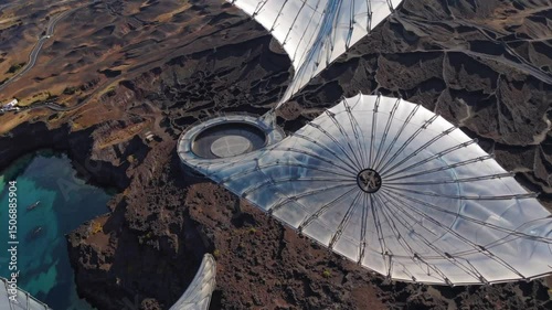 Aerial view of futuristic geodesic domes over rugged coastal landscape